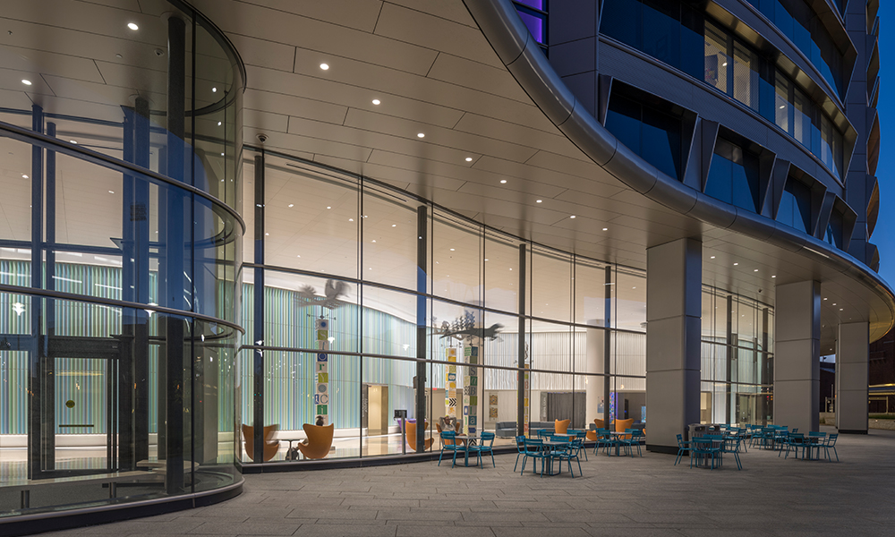 <p>Patients, families, and staff are invited to enjoy the outdoor eating areas, gardens, and play areas, all with views from the inside.  Outside looking in, patients may enjoy the dynamic interior lobby of the building.</p>
