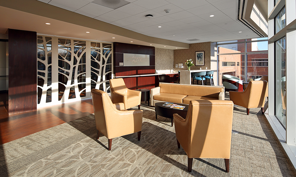 <p>The lofty atrium gives way to the Family Waiting Area, offering the comfort of a fireplace, natural materials and home-like finishes.</p>
