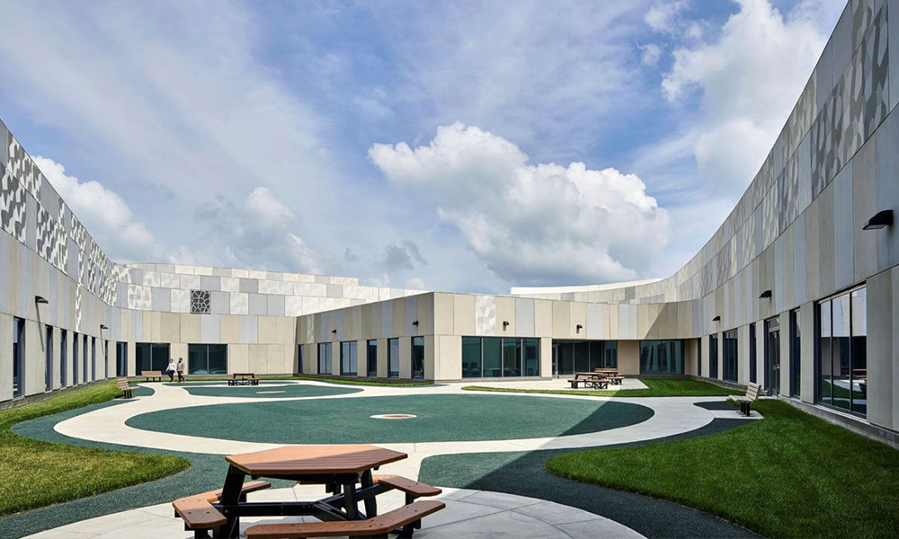 <p>The facility features large windows, a welcoming “front porch” for social events, and a central lawn, providing a park-like atmosphere with walking paths for the surrounding community to enjoy.</p>
