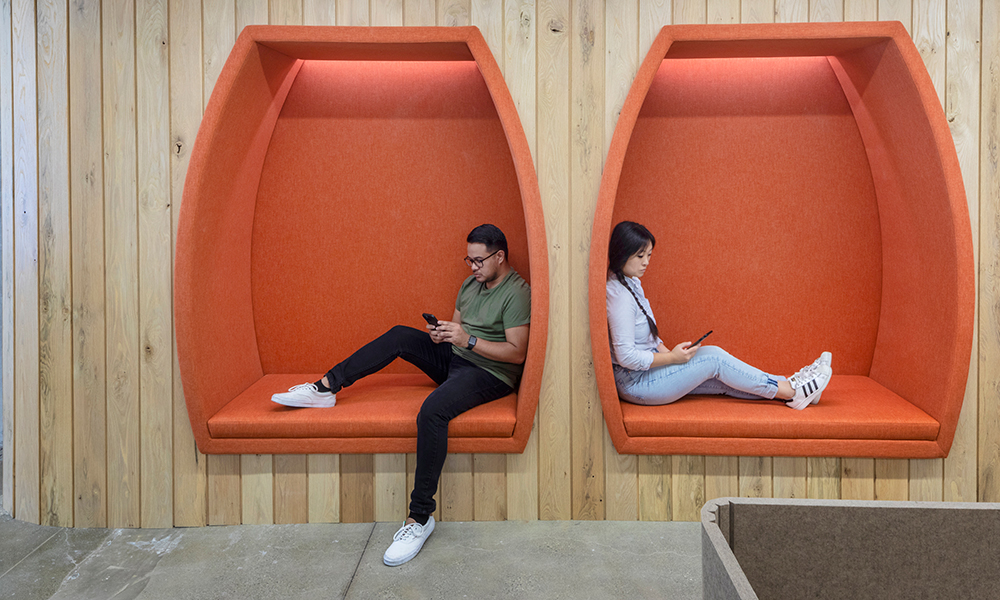 <p>Contrasting bold brand colors with natural materials, banquette niches offer comfortable heads-down spaces for staff.</p>
