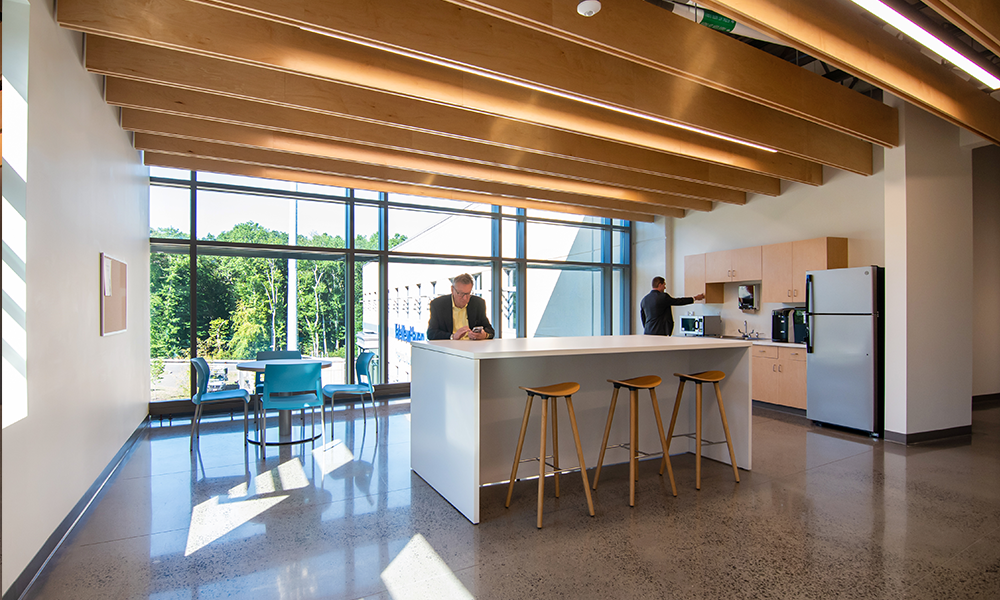 <p>Interior elements include polished concrete floors, visible structure and stainless steel, contrasted by the warmth of natural maple wood beams below exposed ceilings.</p>
